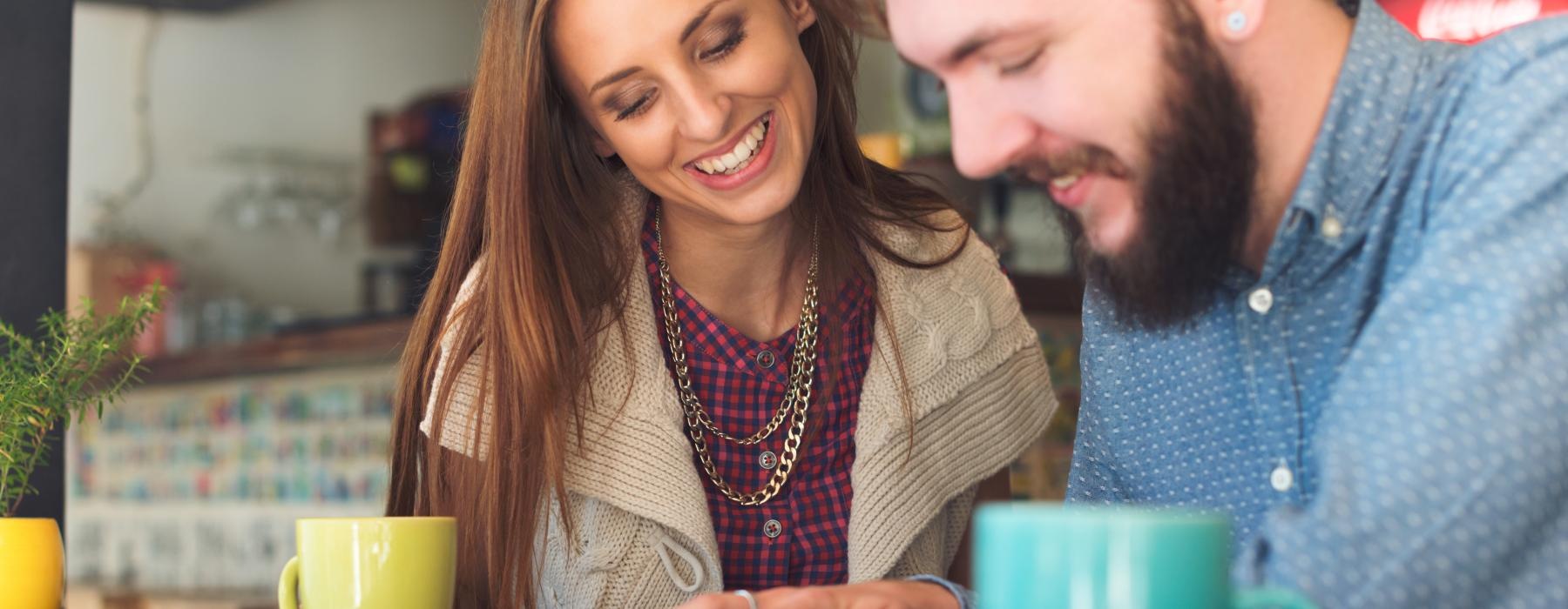 a man and a woman looking at a laptop