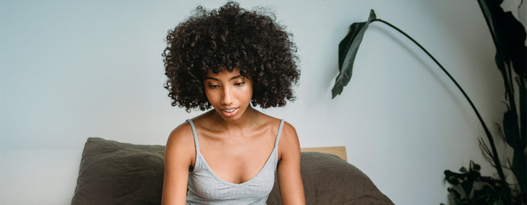 a woman with curly hair and a dog on a bed