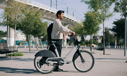 a person walking a bike by a highway