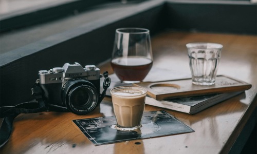 drinks cameras and books on a table