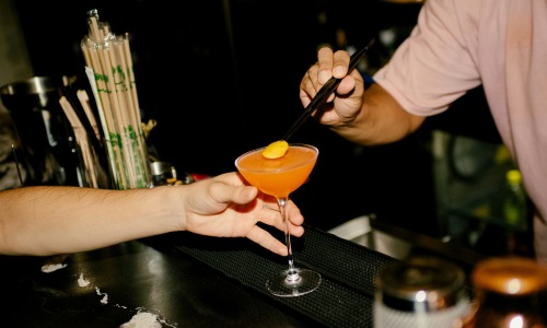 some being served a drink at a bar